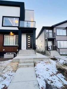 a house with a glass door and stairs in the snow at B21 River Valley 2bd Basement Suite in Edmonton +37 photos