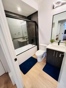 a bathroom with a tub and a toilet and a sink at B21 River Valley 2bd Basement Suite in Edmonton