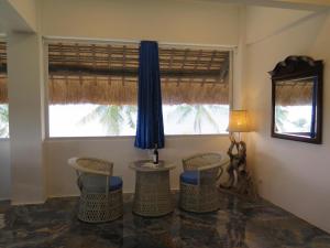 モアルボアルにあるThe Wild Orchid Resort - Moalboalの椅子とテーブル、窓が備わる客室です。