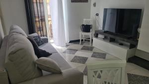 ein Wohnzimmer mit einem Sofa und einem Flachbild-TV in der Unterkunft Casa-cristy in Palermo