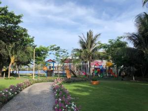 um parque com parque infantil com escorrega e flores em Villa Oceanami - phước hải - bà rịa - vũng tàu em Long Hai