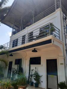 a white building with a balcony on top of it at La Vida Hostel in Puerto Princesa City