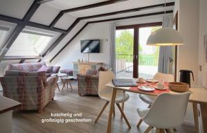 a living room with a table and chairs at Ap Kiebitz - Haus Nordlichter in Wendtorf