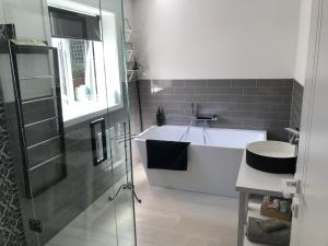 a bathroom with a bath tub and a sink at Villa @23 in Wanaka