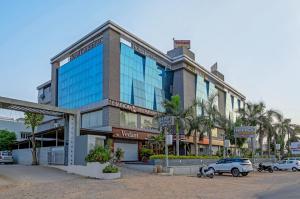 un bâtiment avec des voitures garées devant lui dans l'établissement Hotel Landmark inn, à Ahmedabad