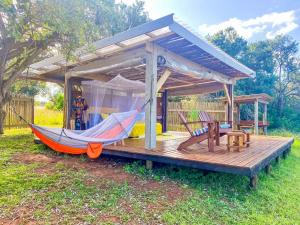 a hammock on a wooden deck with a shed at Hluhluwe Bush Camp Glamping Village in Hluhluwe