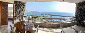 balcón con mesa, sillas y vistas al océano en Puerto Anfi- Luxury- Penthouse- Sleeps 9- Amazing Sea Views en Mogán