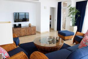 a living room with a blue couch and a table at Penthouse 3 Bedroom Sleeps 8 With 270 deg Sea Views in Mogán