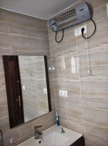 baño con lavabo, espejo y ventilador en Piso compartido cerca de la UNIVERSIDAD CEU, en Moncada