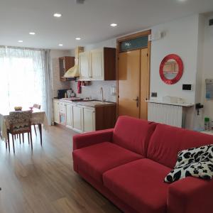 Torricella Peligna的住宿－la Casa sul Corso -- alloggio turistico -- appartamento open space，一间带红色沙发的客厅和一间厨房
