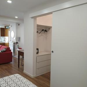 ein Wohnzimmer mit einem roten Sofa und einer Küche in der Unterkunft la Casa sul Corso -- alloggio turistico -- appartamento open space in Torricella Peligna