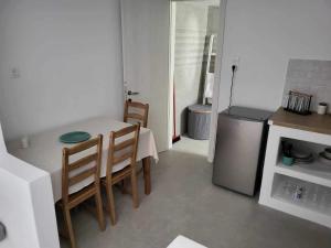 a kitchen with a table and chairs and a refrigerator at Alma Guesthouse in Kithnos