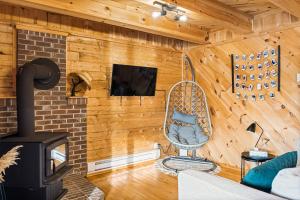 a living room with wooden walls and a wood stove at Knotty Pines 4 Bedroom with Waterfront Views in Chelmsford