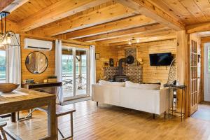 a living room with a couch and a tv at Knotty Pines 4 Bedroom with Waterfront Views in Chelmsford