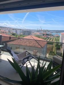 einen Balkon mit einem Stuhl und Stadtblick in der Unterkunft Apartment Welcome in Trogir
