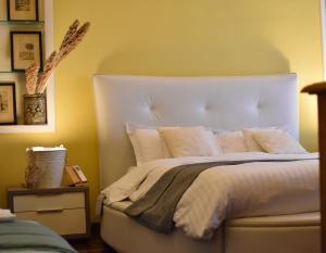 una camera da letto con un grande letto con lenzuola e cuscini bianchi di queen 24 a Taranto