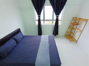 1 dormitorio con cama azul frente a una ventana en D'luna Homestay Terengganu SEA VIEW / DRAWBRIGE VIEW / NEAR HSNZ, KTCC, DRAWBRIGE, en Kuala Terengganu
