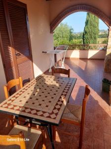 una mesa y sillas en el balcón de una casa en Agriturismo La Verde Rosa, en Pescia Romana