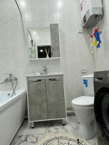 a bathroom with a sink and a toilet and a mirror at 2-ух комнатная люкс квартира in Balqash