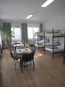 a room with several bunk beds and tables and chairs at Noclegi PODZAMCZE PTTK in Przemyśl