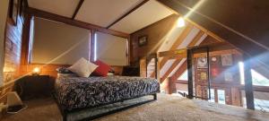 a bedroom with a bed in a room with an attic at The Ponderosa Cabin. in Jindabyne
