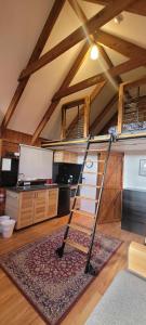 a kitchen with a ladder in the middle of a room at The Ponderosa Cabin. in Jindabyne