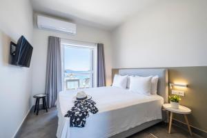 a bedroom with a bed with a hat on it at Nelly's Apartments in Tolo