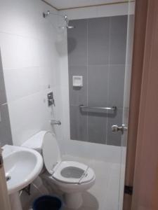 uma casa de banho com um chuveiro, um WC e um lavatório. em Hotel Sogo Edsa Cubao em Manila