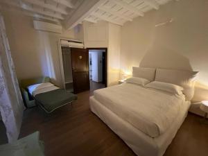 Un dormitorio con una gran cama blanca y una silla. en Ascanio Twenty Six, en Roma