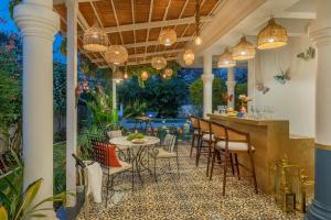 an outdoor patio with a table and chairs at SaffronStays Sweet Mango - 4BR Goan Villa w Private Pool, Mango Garden, Bar Gazebo & Vibrant Interiors Near Beaches in Parra