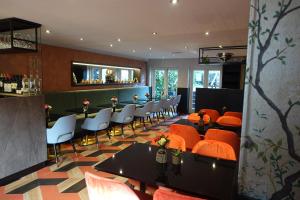 a restaurant with orange chairs and tables and a bar at Prinsengracht Hotel in Amsterdam