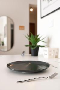 a black plate sitting on a counter with a fork at Harmony Stay Center Xanthi - Meno Homes 6A in Xanthi