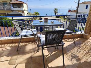 a table and chairs on a balcony with the ocean at Mana mia Seaside Apartments in Leptokarya