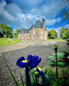 uma casa com uma flor azul em frente dela em Chambres d'hôtes Château de La Croix Chemin em Saint-Léger-des-Prés