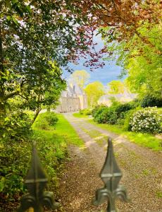 uma estrada de terra com uma casa à distância em Chambres d'hôtes Château de La Croix Chemin em Saint-Léger-des-Prés