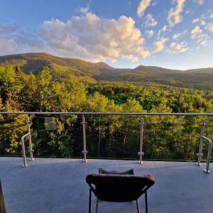 a view from the deck of a house with a chair at Apartamenty KADO (MATEJKI) in Karpacz