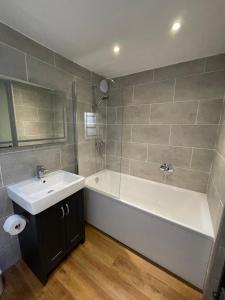 een badkamer met een wit bad en een wastafel bij Royal Hotel in Dockray