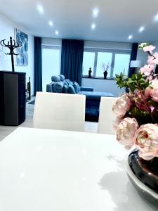 een woonkamer met een bank en een tafel met bloemen bij La Maison Attila en Ardennes in Libin
