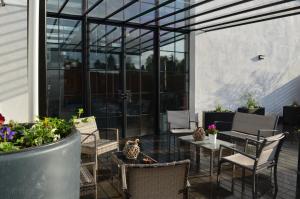 an outdoor patio with chairs and tables and windows at Residences Florale à Thionville - Coliving - Studios - Appartements in Thionville