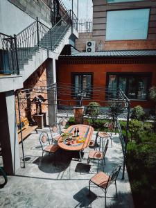 un patio con una mesa y sillas y una escalera en Aspar Boutique Hotel en Ereván