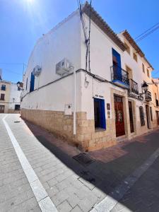 a white building with blue doors on a street at Casa Rural Les Avies cerca del mar in La Nucía