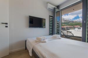 ein Schlafzimmer mit einem Bett und einem großen Fenster in der Unterkunft Luxury Apartment Monika with Shared Pool in Makarska
