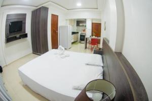 una camera con un grande letto bianco e una cucina di Temporada centro de Manaus, luxo e conforto 703 a Manaus