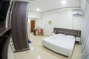 una camera da letto con un letto bianco e un tavolo di Temporada centro de Manaus, luxo e conforto 703 a Manaus
