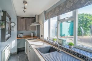 a kitchen with a sink and a large window at L'al Cottage, Sockbridge in Penrith