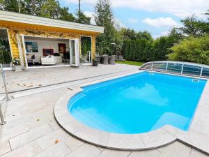 a swimming pool in a yard with a house at 10 person holiday home in arendal-By Traum in Arendal