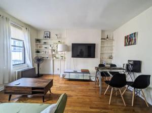 a living room with a table and chairs and a tv at Apartment near Union Square in New York