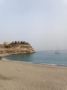 einen Strand mit einem Boot im Wasser in der Unterkunft Stefanelli Tropea Home in Tropea