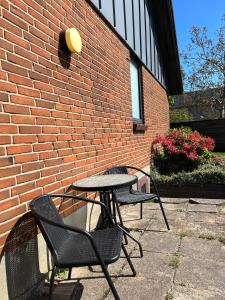 two chairs and a table in front of a brick building at The Heart of Billund apartment in Billund