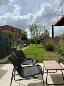 2 Stühle und ein Tisch auf der Terrasse in der Unterkunft maison cosy centre-ville in Lens